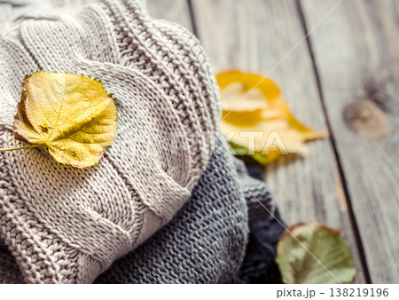 a stack of sweaters and autumn leaves a stack of sweaters and autumn leaves 138219196