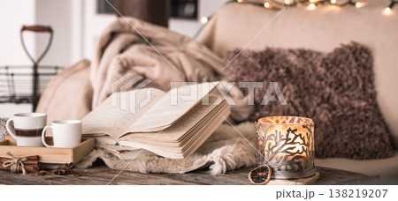 still life home atmosphere in the interior with cups, a book and candles, on the background of cozy bedspreads still life home atmosphere in the interior with cups, a book and candles, on the background of cozy bedspreads 138219207