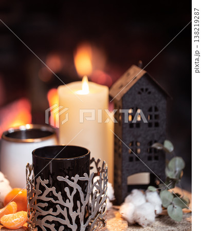 Cozy composition with a cup, candle and tangerines on a blurred background. Cozy composition with a cup, candle and tangerines on a blurred background. 138219287