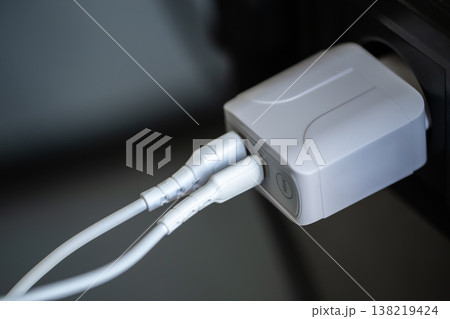 White USB charging for gadgets on a blurred background of the room, close-up. White USB charging for gadgets on a blurred background of the room, close-up. 138219424