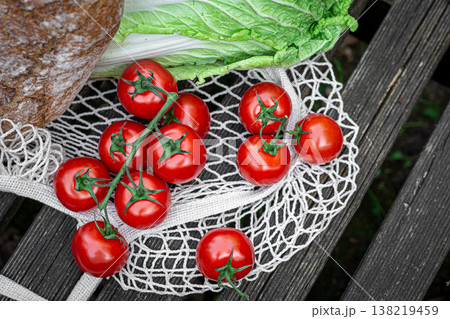 Vegetables and bread in a shopping bag on a wooden surface. 138219459