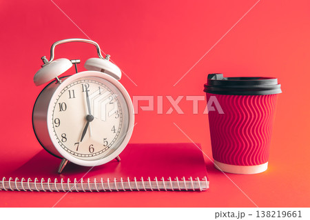 White alarm clock, paper cup and notepad on a blurred background. 138219661