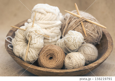 Wooden bowl with threads for knitting yarns close-up. Wooden bowl with threads for knitting yarns close-up. 138219791