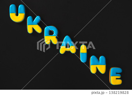 The word Ukraine on a black background, made with handmade gingerbread. The word Ukraine on a black background, made with handmade gingerbread. 138219828