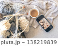 Yarn threads, knitted elements and a cup of coffee, top view. 138219839
