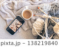 Yarn threads, knitted elements and a cup of coffee, top view. 138219840