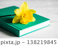 Yellow flower and book on a blurred white background, close-up. 138219845