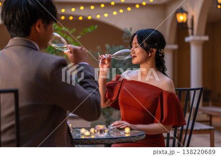 ナイトウェディング,ディナーでシャンパンを飲むドレスコードしたカップル ナイトウェディング,ディナーでシャンパンを飲むドレスコードしたカップル 138220689