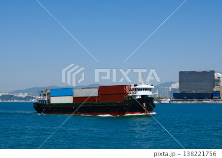 Container cargo ship with colorful containers sailing on Hong Kong Victoria Harbour on clear sunny day Container cargo ship with colorful containers sailing on Hong Kong Victoria Harbour on clear sunny day 138221756