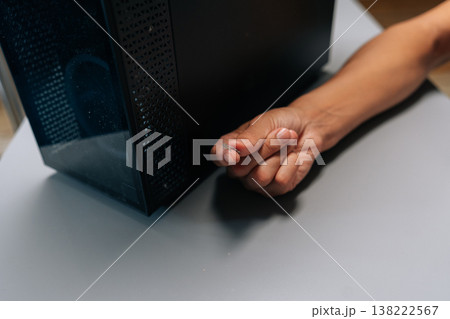 Close-up of unrecognizable man holding dust bunny after cleaning dusty computer case, emphasizing necessity of regular maintenance for ensuring optimal performance and preventing potential issues. Close-up of unrecognizable man holding dust bunny after cleaning dusty computer case, emphasizing necessity of regular maintenance for ensuring optimal performance and preventing potential issues. 138222567
