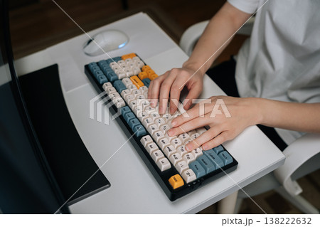 Top view of hands typing on colorful mechanical keyboard, symbolizing dedication to work, study, gaming, efficient use of modern computer hardware and digital technology, close-up, cropped shot. Top view of hands typing on colorful mechanical keyboard, symbolizing dedication to work, study, gaming, efficient use of modern computer hardware and digital technology, close-up, cropped shot. 138222632