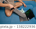 Close-up hand of person cleaning laptop keyboard with duster, removing dust and debris for hygiene, ensuring device maintenance and clean home office, providing care for personal electronics. 138222936