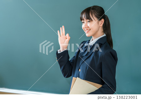 教室の黒板の前で教科書を持つ制服姿の小学生,中学生,高校生の女子生徒 教室の黒板の前で教科書を持つ制服姿の小学生,中学生,高校生の女子生徒 138223001