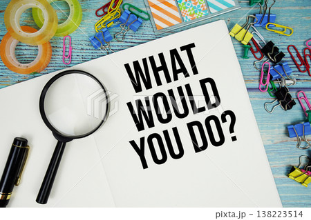 What Would You Do? text on a paper surrounded by office supplies and magnifying glass on a blue wooden surface What Would You Do? text on a paper surrounded by office supplies and magnifying glass on a blue wooden surface 138223514