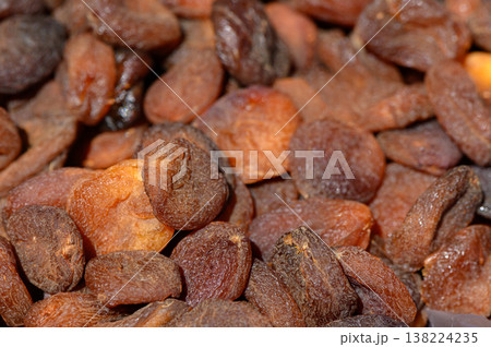 Dried apricots glimmering under warm light create a tempting treat found in vibrant markets Dried apricots glimmering under warm light create a tempting treat found in vibrant markets 138224235