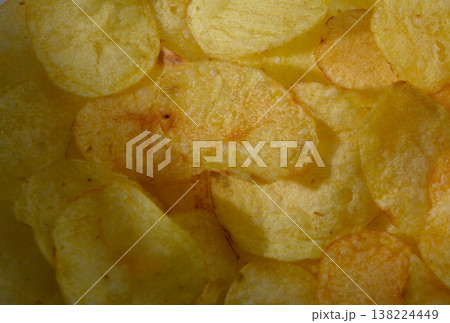 Crispy golden chips scattered joyfully on a bright background celebrating snack time during a sunny afternoon 138224449