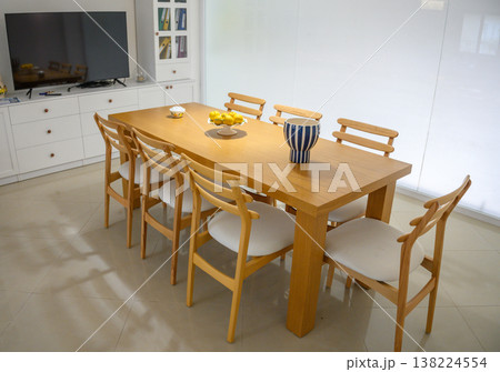 Elegant wooden dining table adorned with citrus centerpiece in a modern bright kitchen setting 138224554