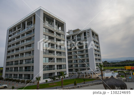 Modern architectural marvels rise against a cloudy sky near a serene outdoor space in a tranquil setting Modern architectural marvels rise against a cloudy sky near a serene outdoor space in a tranquil setting 138224695