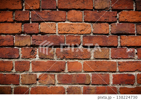 Textured red brick wall showcasing rustic details and weathered charm in urban settings Textured red brick wall showcasing rustic details and weathered charm in urban settings 138224730