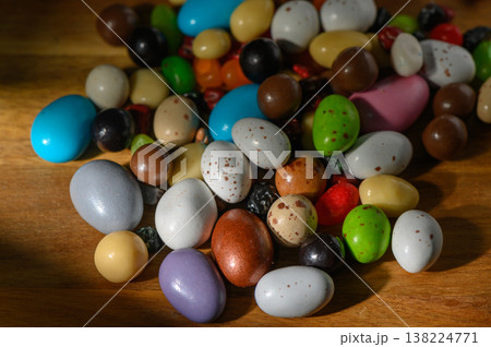 Colorful assortment of candies spreads out on a wooden surface inviting a delightful treat experience Colorful assortment of candies spreads out on a wooden surface inviting a delightful treat experience 138224771