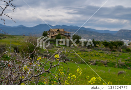 Rolling hills embrace an abandoned house under a brooding sky in rural landscape Rolling hills embrace an abandoned house under a brooding sky in rural landscape 138224775