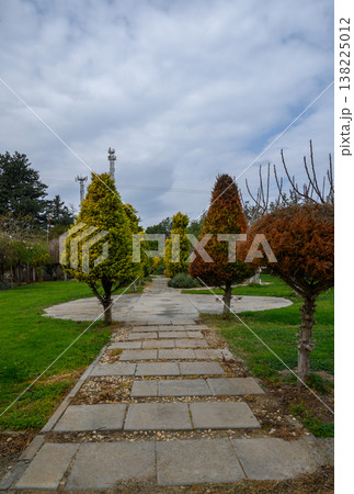 Beautiful landscaped pathway surrounded by vibrant trees in a serene park in springtime Beautiful landscaped pathway surrounded by vibrant trees in a serene park in springtime 138225012