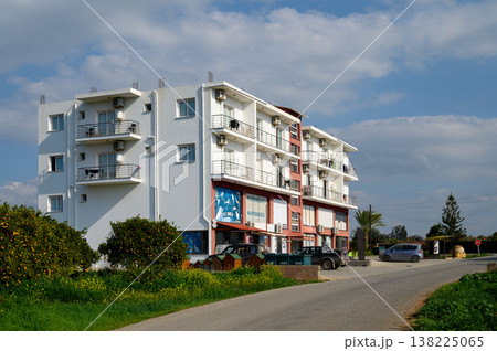 Modern building along a quiet road surrounded by greenery and blue skies in a serene neighborhood 138225065