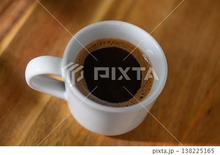 Rich aroma fills the air as a steaming cup of coffee sits on a wooden table Rich aroma fills the air as a steaming cup of coffee sits on a wooden table 138225165