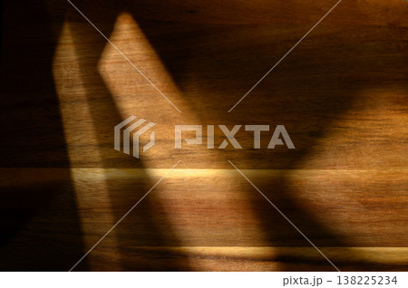 Shadows dance gracefully across a wooden surface during twilight hours, creating Shadows dance gracefully across a wooden surface during twilight hours, creating 138225234