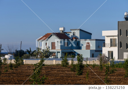 Charming blue house surrounded by lush fields during a serene afternoon in Charming blue house surrounded by lush fields during a serene afternoon in 138225250