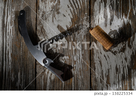 Corkscrew and cork resting on a weathered wooden surface in soft afternoon light Corkscrew and cork resting on a weathered wooden surface in soft afternoon light 138225334