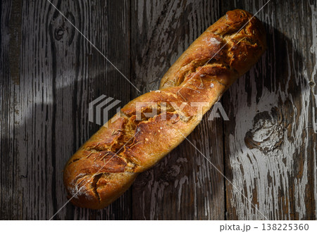Freshly baked artisan bread resting rustic wooden table in warm afternoon light Freshly baked artisan bread resting rustic wooden table in warm afternoon light 138225360