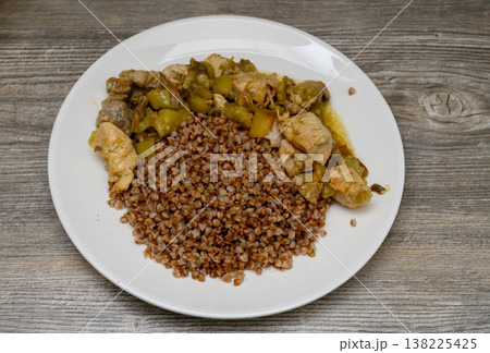 A traditional Eastern European dish served for lunch. An appetizing presentation in a deep bowl against the texture of a wooden table or countertop creates a cozy atmosphere. A traditional Eastern European dish served for lunch. An appetizing presentation in a deep bowl against the texture of a wooden table or countertop creates a cozy atmosphere. 138225425
