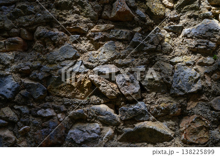Textured old stone wall inside St. Hilarion Castle, lit with natural light spots. A dramatic and historic backdrop full of medieval atmosphere. 138225899