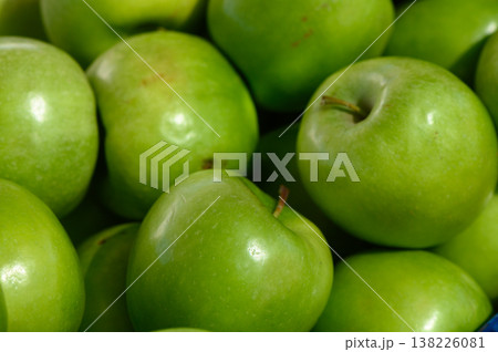 Fresh green apples gathered in a vibrant display at a local market during the sunny morning hours of early autumn Fresh green apples gathered in a vibrant display at a local market during the sunny morning hours of early autumn 138226081