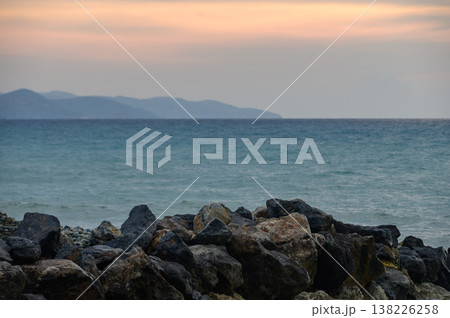 Stunning sunset view over the Mediterranean Sea with silhouettes of mountains along the Cyprus coastline. Warm tones, calm water, and serene natural scenery. 138226258