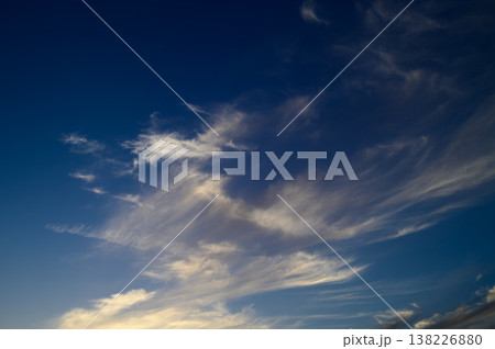 Beautiful wispy clouds dance across the evening sky at twilight, creating Beautiful wispy clouds dance across the evening sky at twilight, creating 138226880