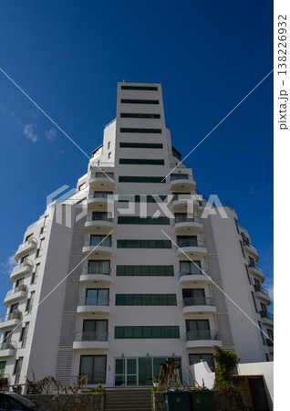 Modern architectural marvel stands tall against the brilliant blue sky in a vibrant cityscape 138226932