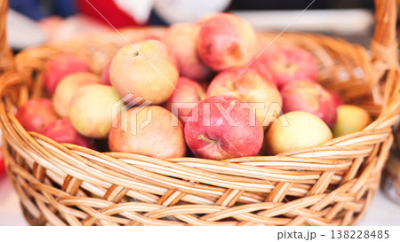 Red and yellow apples filling wicker basket harvest 138228485