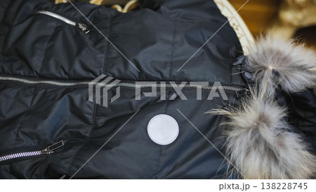 Black puffer jacket with fur collar and zippers providing warmth and winter fashion Black puffer jacket with fur collar and zippers providing warmth and winter fashion 138228745