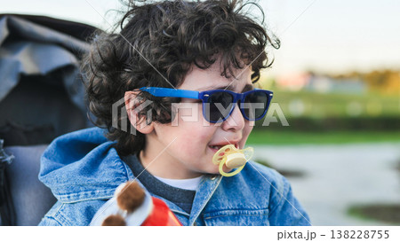Crying toddler wearing sunglasses and pacifier, expressing sadness outdoors Crying toddler wearing sunglasses and pacifier, expressing sadness outdoors 138228755