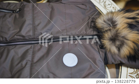 Brown winter jacket with fur collar, zippers, and white blank sticker for branding 138228779