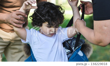 Parents helping child getting dressed, promoting family support and childhood development 138229018