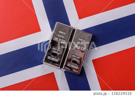 A silver bar against a backdrop of Norway flag, as a concept for the sales market. A silver bar A silver bar against a backdrop of Norway flag, as a concept for the sales market. A silver bar 138229310