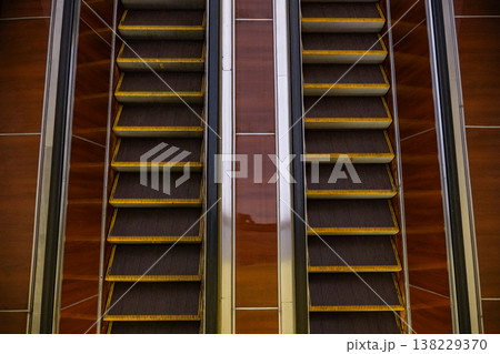 Escalators moving up and down in modern building interior, creating parallel lines Escalators moving up and down in modern building interior, creating parallel lines 138229370