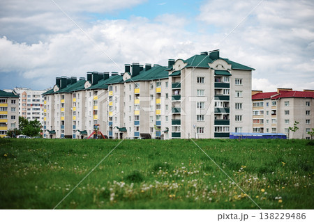 Apartment building complex with green roofs and balconies facing a large grass field Apartment building complex with green roofs and balconies facing a large grass field 138229486