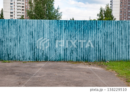 Teal corrugated metal fence in urban setting with building and trees Teal corrugated metal fence in urban setting with building and trees 138229510