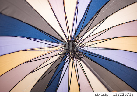 Colorful umbrella canopy creating abstract pattern of lines and geometric shapes Colorful umbrella canopy creating abstract pattern of lines and geometric shapes 138229715