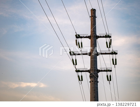 Power lines extending from an electric utility pole against a cloudy sky Power lines extending from an electric utility pole against a cloudy sky 138229721