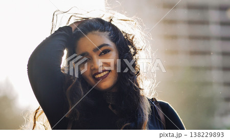 Bangladeshi woman smiling in Moscow with backlit hair and city background 138229893